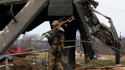 Un militar ucraniano lleva su arma bajo un puente dañado, en medio de la invasión rusa de Ucrania, en Irpin. REUTERS/Zohra Bensemra