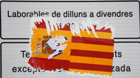 Una pegatina con la bandera española y la senyera, rasgada en un cartel Barcelona. REUTERS Una pegatina con la bandera española y la senyera, rasgada en un cartel Barcelona. REUTERS