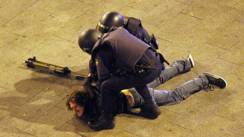 Dos antidisturbios inmovilizan en el suelo a un periodista, el día 14 de mayo de 2012, durante el desalojo de Sol en el primer aniversario del movimiento.- EFE Dos antidisturbios inmovilizan en el suelo a un periodista, el día 14 de mayo de 2012, durante el desalojo de Sol en el primer aniversario del movimiento.- EFE