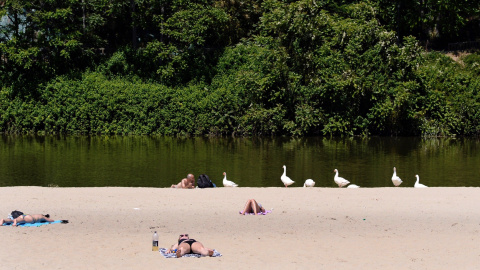 Un grupo de personas toma el sol en la playa de Las Moreras en Valladolid, ciudad en la que, al igual que en el resto de la Península, las temperaturas han subido hasta superiores a los 30 grados centígrados. | EFE