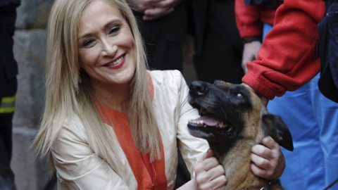 La presidenta regional, Cristina Cifuentes, acaricia a uno de los perros del Servicio de Emergencia y Respuesta Inmediata de la Comunidad de Madrid (Ericam) que ha recibido una de las encomiendas de número de la Orden del Dos de Mayo, en lo
