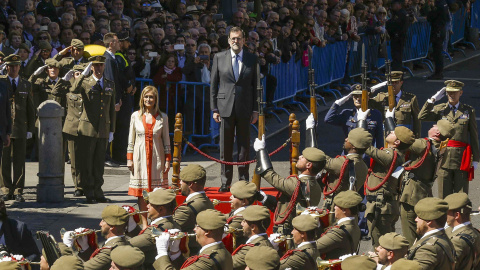 El presidente del Gobierno en funciones, Mariano Rajoy, y la presidenta de la Comunidad de Madrid, Cristina Cifuentes, escuchan el himno durante la tradicional parada y desfile militar que se ha celebrado en la Puerta de Sol, con motivo del