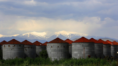 Silos abandonados frente al nevado monte Olimpo, cerca de la ciudad de Larissa en la región de Tesalia, Grecia.- REUTERS / Yannis Behrakis
