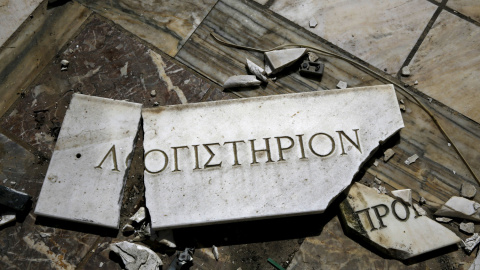Una placa de mármol rota en la que se lee "Oficina del Contador", en el suelo de una fábrica de mármol abandonada que se cerró en 2006 cerca de la ciudad de Larissa en la región de Tesalia, Grecia .- REUTERS / Yannis Behrakis