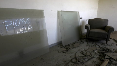 una marca sobre el polvo pide ayuda desde el interior de la oficina de un gerente de una fábrica textil cerrada en 1995 cerca de la ciudad de Larissa en la región de Tesalia, Grecia.- REUTERS / Yannis Behrakis
