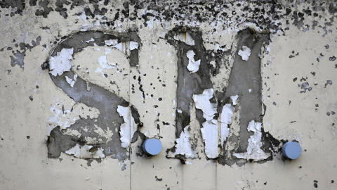 El logotipo destruido de una fábrica textil cerrada en 2003 se ve en la ciudad de Tebas, en la región Sterea Hellas, Grecia.- REUTERS / Yannis Behrakis