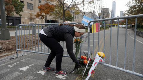Una mujer deposita flores en la barrera colocada en el caril-bici junto al rio Hudson donde se produjo el ataque terrorista que ha causado la muerte a ocho peatones y ciclistas, arrollados por una furgoneta conducida por un inmigrante uzbek Una mujer deposita flores en la barrera colocada en el caril-bici junto al rio Hudson donde se produjo el ataque terrorista que ha causado la muerte a ocho peatones y ciclistas, arrollados por una furgoneta conducida por un inmigrante uzbek