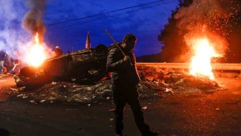 Un pescador camina junto a una barricada que bloquea una carretera durante una protesta que reclama al Gobierno ayuda para la aliviar los efectos económicos de un brote de algas nocivas que había afectado a sus medios de vida en Ancud en la