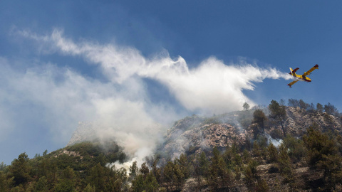Medios aéreos siguen refrescando hoy el área del incendio forestal declarado ayer cercano a la localidad alicantina de Pego. EFE/NATXO FRANCÉS Medios aéreos siguen refrescando hoy el área del incendio forestal declarado ayer cercano a la localidad alicantina de Pego. EFE/NATXO FRANCÉS