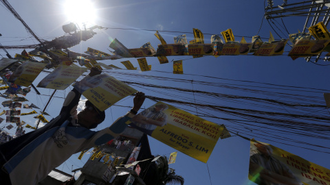 Un activista coloca carteles electorales en una calle de Manila, Filipinas. EFE/Ritchie B. Tongo