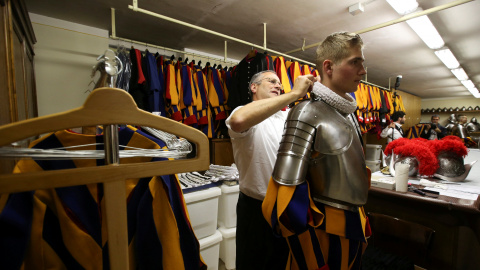 Un nuevo guardia suizo del Vaticano es ayudado a ajustar su uniforme antes de la ceremonia de toma de posesión en el Vaicano. REUTERS / Stefano Rellandini