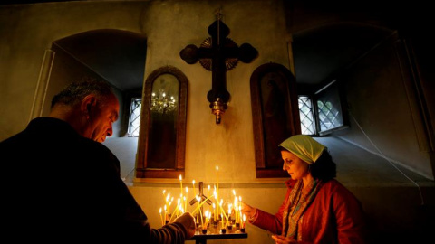 Varios fieles encienden velas durante un servicio religioso por el día de San Jorge en la catedral ortodoxa de Kashveti, en Tiflis, Georgia. EFE/Zurab Kurtsikidze