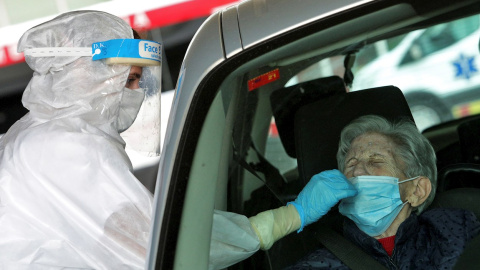 Una sanitaria protegida con EPI toma una muestra para una prueba PCR frente al hospital de Gandía. Una sanitaria protegida con EPI toma una muestra para una prueba PCR frente al hospital de Gandía.