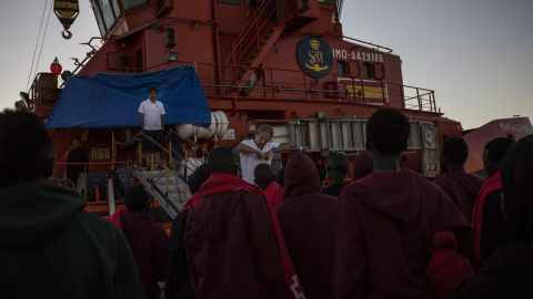 El capitán de la Guardamar María Zambrano, Ángel Téllez, habla con los migrantes atrapados en el puerto de Algeciras antes de que suban al barco en el que pasarán la noche por falta de espacio en otras estancias. JAIRO VARGAS