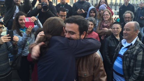 Alberto Garzón, líder de Izquierda Unida, y Pablo Iglesias, secretario general de Podemos, se abrazan en la Puerta del Sol de Madrid, para rubricar su acuerdo electoral. PODEMOS