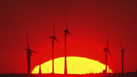 El sol ilumina las turbinas de un parque eólico cerca del cruce de la autopista de Pankow, en una foto tomada desde la colina de Drachenberg, en Berlín (Alemania) al amenecer. EFE/Paul Zinken