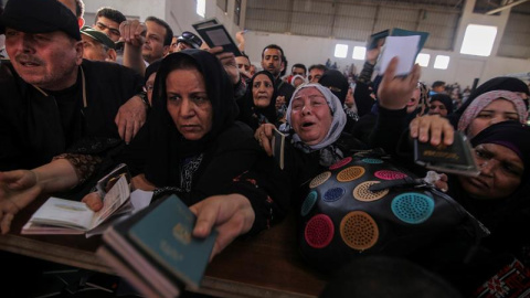Varios palestinos muestran sus pasaportes a los policías fronterizos en el paso fronterizo de Rafah, en la franja de Gaza. EFE/Khaled Omar