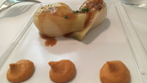 Cebolleta estofada con cerveza y romesco.