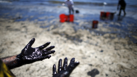 Varios voluntarios limpian una de las playas afectadas por el vertido. / LUCY NICHOLSON (REUTERS) Varios voluntarios limpian una de las playas afectadas por el vertido. / LUCY NICHOLSON (REUTERS)