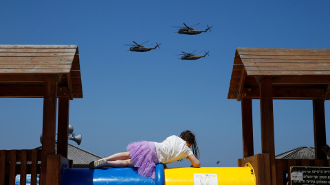 Una niña mira como helicópteros de la Fuerza Aérea de Israel vuelan sobre el mar Mediterráneo durante las celebraciones para el Día de la Independencia de Israel en Tel Aviv. REUTERS/Baz Ratner