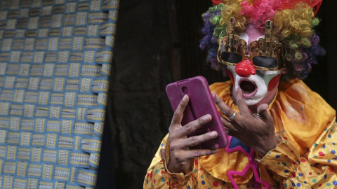 El joven Altaf Ahmed, de 28 años y con una discapacidad física, se prepara para entretener a los viandantes como payaso en Bombay, India. EFE/Divyakant Solanki