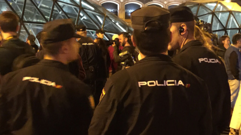 Agentes de la Policía Nacional vigilan a los asistentes a la concentración convocada por el movimiento 15-M para emitir un "grito silencioso" justo al comienzo de la jornada de reflexión, pese a la prohibición de la Junta Electoral Central.