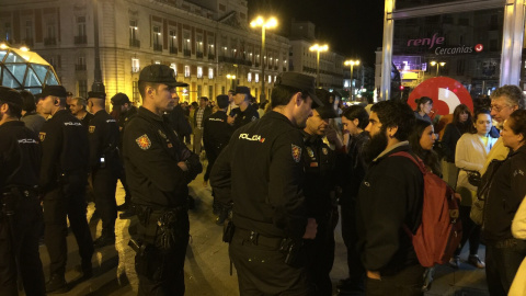 Agentes de la Policía Nacional identifican a uno de los asistentes a la concentración convocada por el movimiento 15-M para emitir un "grito silencioso" justo al comienzo de la jornada de reflexión, pese a la prohibición de la Junta Elector