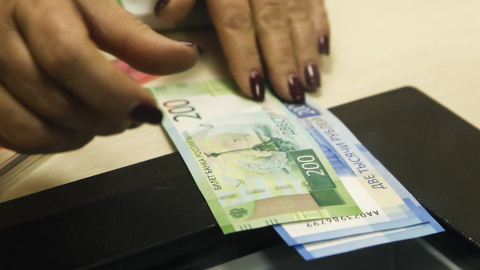 Una cajera con billetes de 200 y de 2.000 rublos, en un banco de Moscu. REUTERS/Maxim Shemetov Una cajera con billetes de 200 y de 2.000 rublos, en un banco de Moscu. REUTERS/Maxim Shemetov