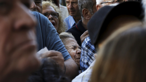 Una pensionista es aplastada mientras espera fuera de una sucursal del Banco Nacional para recibir parte de su pensión en Atenas. / REUTERS - ALKIS KONSTANTINIDIS