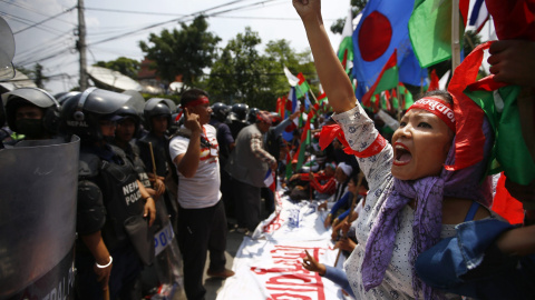na simpatizantes de las minorías étnicas grita consignas antigobierno frente a los agentes antidisturbios durante una marcha hacia la sede del Gobierno durante para protestar a favor de una nueva división administrativa en Nepal, en Katmand
