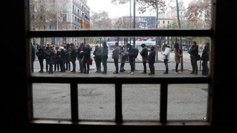 Numerosos ciudadanos guardan cola en el colegio electoral de la Plaza de la Universidad de la ciudad condal. / EFE