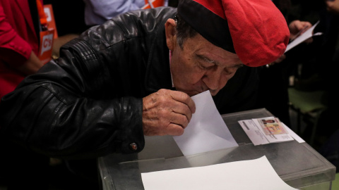 Un hombre acude a votar con la barretina puesta. / Reuters