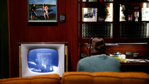 Un visitante mira imágenes del aterrizaje lunar en una recreación de la sala de estar de los años 60. Reuters