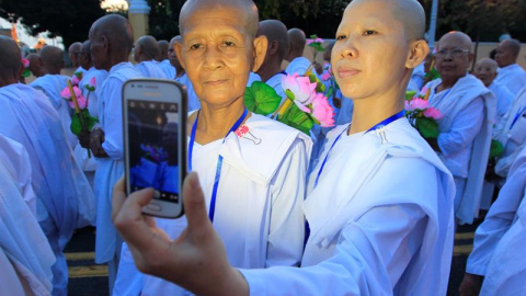 Dos monjas budistas se hacen un selfie durante las celebraciones del Vesak Bochea en Phnom Penh, en Camboya. EFE/Kith Serey