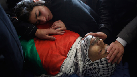 La hija del ministro palestino Ziad Abu Ein, llora sobre su cuerpo durante el funeral en la ciudad cisjordana de Ramala. Abu Ein murió a manos de un policía israelí, lo que ha elevado las tensiones en la zona. //  MOHAMAD TOROKMAN (REUTERS)