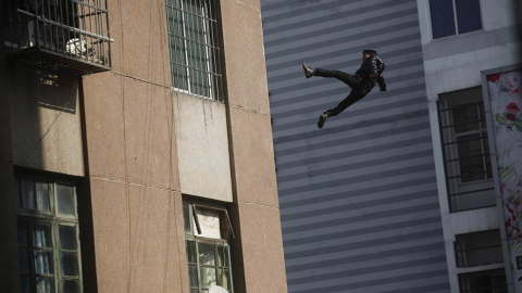 Un hombre cae desde lo alto de un edificio residencial en Loizhou. Según los medios locales el hombre, que no sobrevivió a la caída, resbaló mientras la gente trataba de convencerle de que abandonara la azotea. // REUTERS/STR