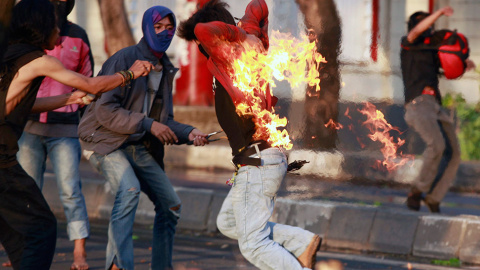 Un manifestante indonesio corre tras ser alcanzado por el fuego mientras lanzaba un cóctel molotov a la policía durante una protesta por el incremento de los precios del combustible. // AHMAD YUSUF (REUTERS)