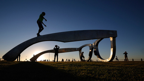Unos jóvenes sobre una escultura en forma de gafas gigantes, en Ciudad del Cabo (Suráfrica). // MIKE HUTCHINGS (REUTERS)
