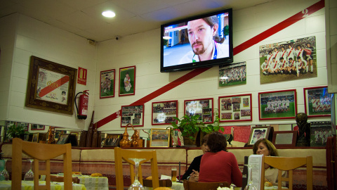 Los comensales del restaurante Cota, bajo una pantalla de televisión con el líder de Podemos -también de Vallecas- en las noticias. // CHRISTIAN GONZÁLEZ