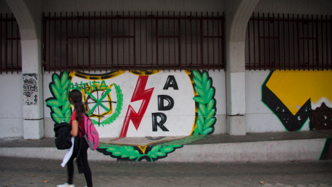 Una niña pasa junto al estadio al regresar del colegio. // CHRISTIAN GONZÁLEZ