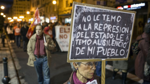 Una mujer porta una pizarra con un mensaje durante "Marxes per la dignitat", en Valencia. // EFE