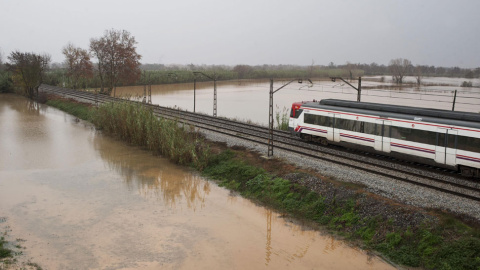 La vía del tren a la salida de Figueres (Girona) en dirección a la frontera francesa rodeada de campos inundados. // EFE