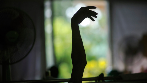 Un enfermo terminal de Sida levanta su brazo, en un hospicio en el templo budista de Wat Prabat Nampu, en la provincia de Lopburi, al norte de Bangkok. // DAMIR SAGOLJ (REUTERS)