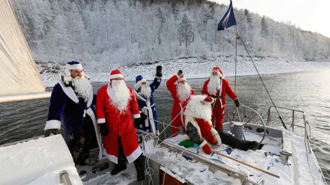 Los miembros de un club náutico vestidos de Papá Noël, saludan a la tripulación de otro barco. // LLYA NAYMUSHIN (REUTERS)