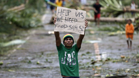 Un filipino con un cartel reclamando ayuda para las víctimas del tifón Hagupit, en la ciudad Taft, en la isla de Samar. // EFE/EPA/FRANCIS R. MALASIG