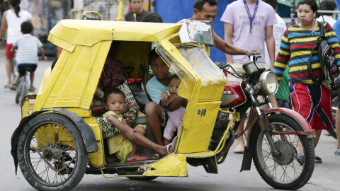 Una familia filipina se dirige en su triciclo a un centro de evacuación en Manila. // EFE/EPA/DENNIS M. SABANGAN