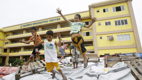 Un grupo de niños filipinos juegan junto a uno de los centros de evacuación en Manila. // EFE/EPA/DENNIS M. SABANGAN
