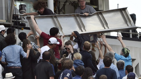 Espectadores intentan apartar la placa caída en la grada de la pista Phillipe Chatrier. /AFP Espectadores intentan apartar la placa caída en la grada de la pista Phillipe Chatrier. /AFP