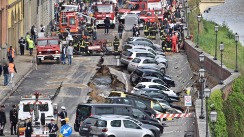 Varios vehículos aparecen engullidos por un socavón cerca del famoso Puente Viejo a orillas del río Arno, en el centro de la ciudad italiana de Florencia (Italia). EFE/Maurizio Degl' Innocenti
