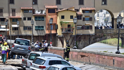 Los servicios de emergencia trabajan en la retirada de los vehículos engullidos por un socavón cerca del famoso Puente Viejo a orillas del río Arno, en el centro de la ciudad italiana de Florencia. EFE/Maurizio Degl' Innocenti